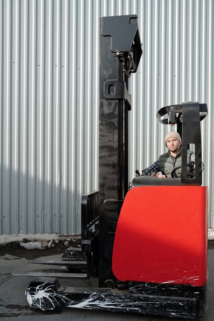 A forklift operator working outdoors in an industrial environment.